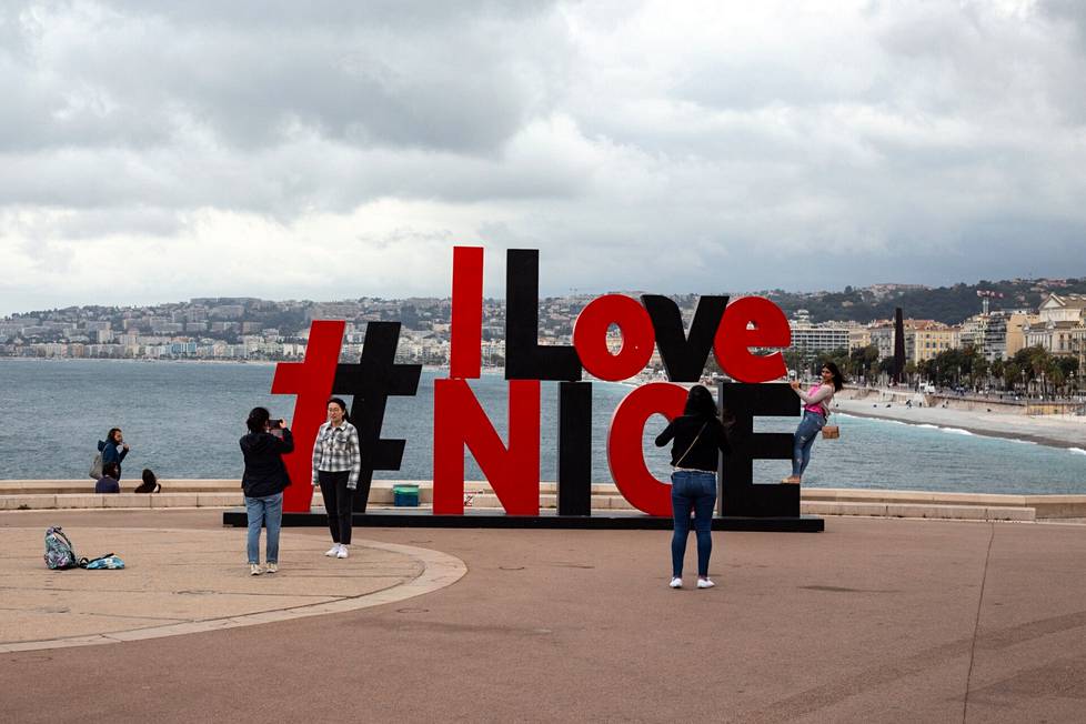 Turisteja Nizzan rantapromenadilla.