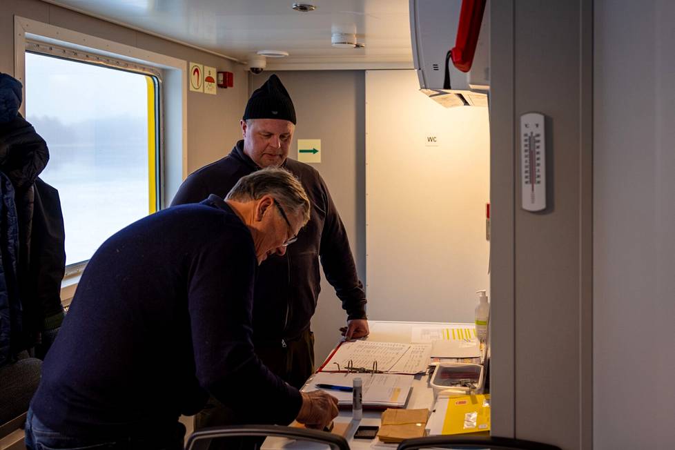 Ville Pettersson watches closely how election official Göran Lindqvist stamps his ballot.