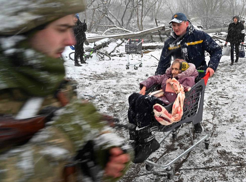 Ukrainalaista naista evakuoitiin ostoskärryillä Irpinistä Kiovan luoteispuolelta tiistaina.