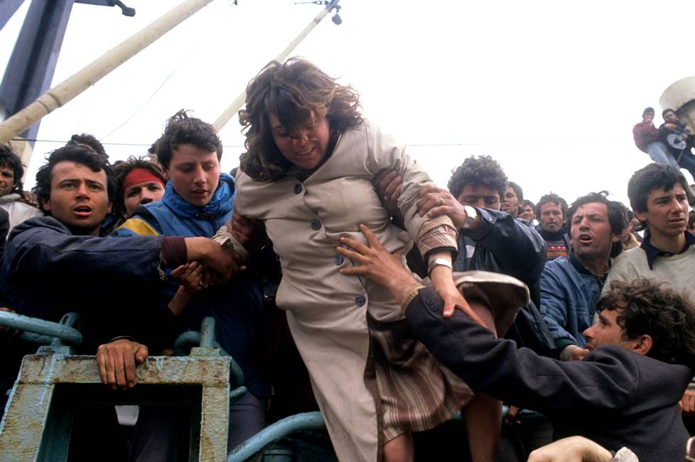 Raskaana olevaa albanialaisnaista autetaan Brindisissä Italiassa 1991.
