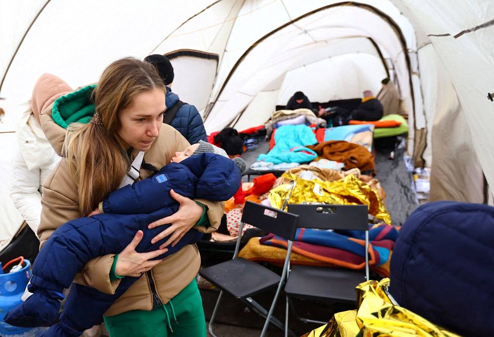 Nainen kantoi vauvansa telttaan lämpimään Medykassa Puolassa heidän ylitettyään Puolan ja Ukrainan rajan.