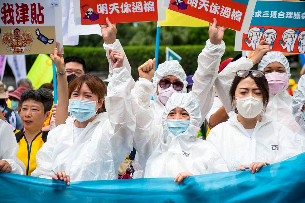 Taiwanilaiset sairaalatyöntekijät osallistuivat protestiin Taipeissa presidentinlinnan edustalla pukeutuneina suojavarusteisiin.