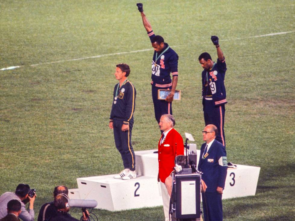 Olympiavoittaja Tommie Smith (kesk.) ja pronssimitalisti John Carlos järjestivät urheiluhistorian ikonisimman protestin 200 metrin pikajuoksun olympiafinaalin jälkeen Méxicossa 1968. Hopeamitalisti Australian Peter Norman (oik.) tuki protestia rintamerkillään.