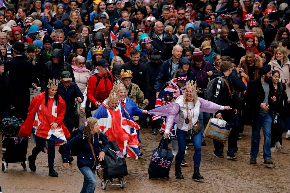 Väkijoukko juoksee kohti Buckinghamin palatsin parveketta kruunajaisten jälkeen.