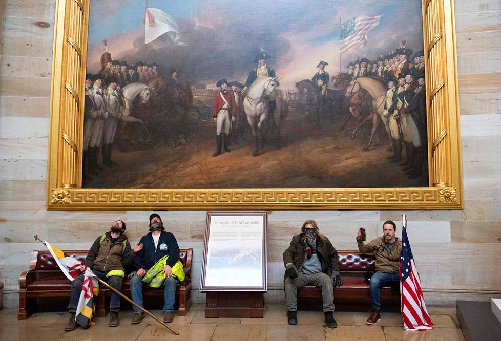 Presidentti Trumpin kannattajat istuivat Yhdysvaltain kongressin rotundassa. Taustalla John Trumbullin vuoden 1826 maalaus, joka kuvastaa Britannian kenraaliluutnantti Charles Earl Cornwallisin antautumista Yorktownissa Virginiassa 19. lokakuuta 1781. Yorktownin piirityksen päättyminen käytännössä vahvisti Yhdysvaltojen itsenäistymisen Britanniasta.