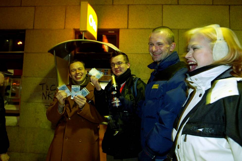 Markan lähtöä ja euron tuloa juhlittiin. Visa Noronen (vas.), Janne Sormunen, Jorma Sormunen ja Suvi Sormunen juhlistivat ensimmäisiä euronostoja samppanjalla heti puolenyön jälkeen 1. tammikuuta 2002 Helsingissä Postikadun automaatilla.