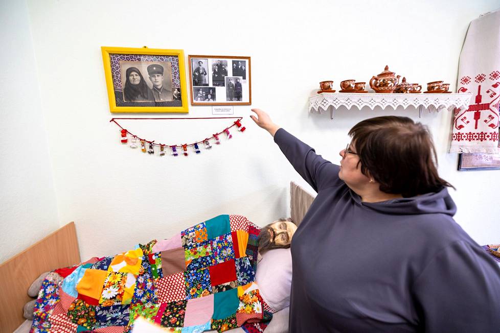 Natalia Kožanova esittelee Venäjän kulttuurikeskuksen seinällä olevaa isovanhempiensa kuvaa huoneessa, joka on sisustettu viime vuosisadan alun tapaan. Kožanova pyrkii säilyttämään katoavaa kulttuuriperintöä.