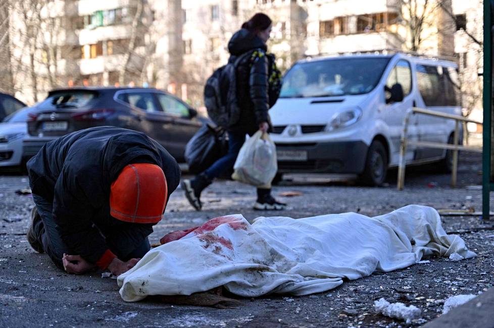 Mies suri ohjusiskussa kuollutta uhria Kiovassa.