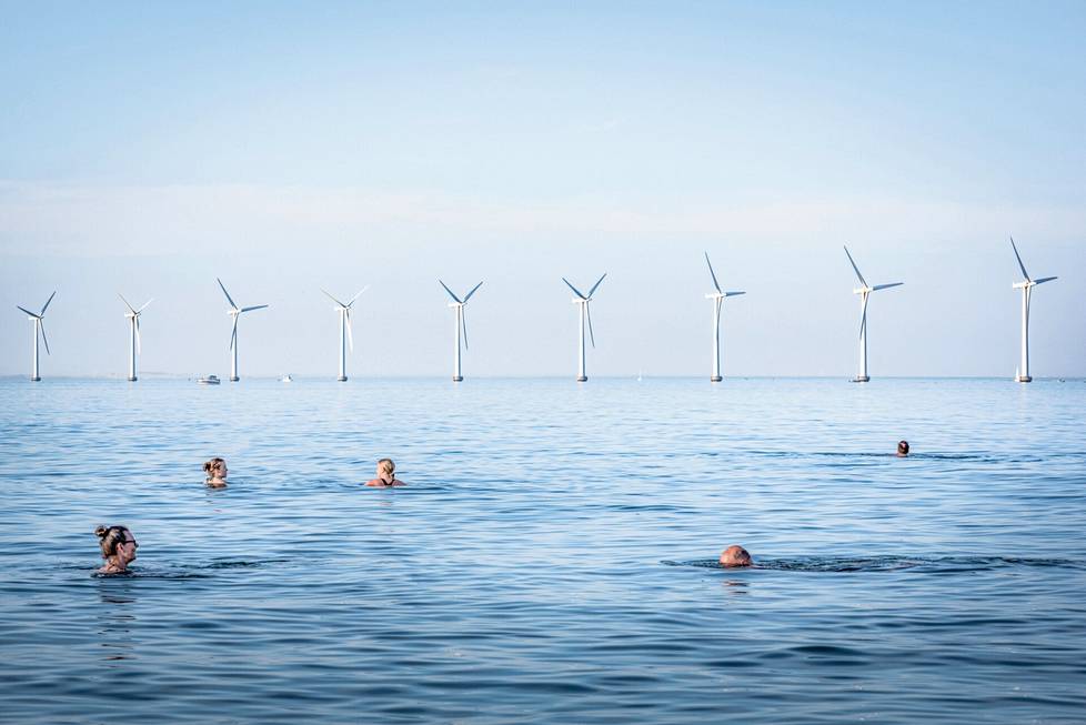 Ihmiset uivat Amager Strandissa Tanskassa heinäkuussa 2021. Lähellä sijaitseva tuulivoimala on  8 552 sähkönkäyttäjän yhdessä omistama ja se tuottaa sähköä yli 40 000  kotitaloudelle Kööpenhaminassa. Valokuvaaja Simone Tramonte dokumentoi innovatiivisia teknologioita, joiden avulla ihmiskunta voi saavuttaa tavoitteet kasvihuonepäästöjen hillitsemiseksi. Tramonte voitti Euroopan pitkä valokuvausprojekti -sarjan.