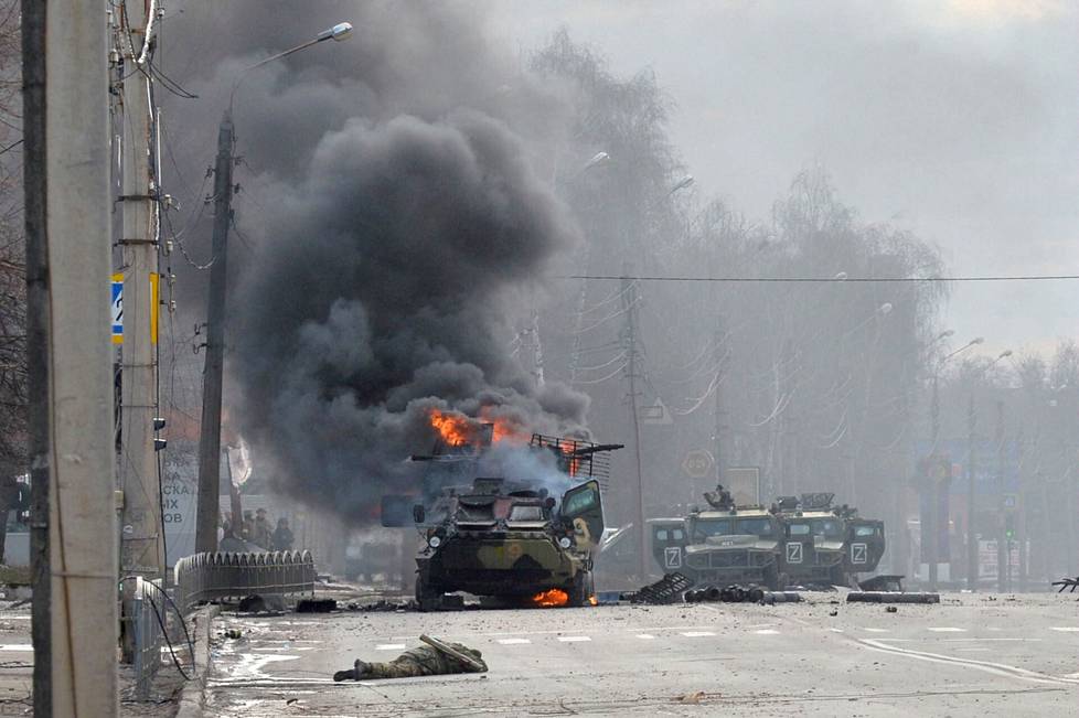 Eri arvioiden mukaan Ukrainassa on kuollut tuhansia Venäjän taistelijoita. Kuvassa palava venäläinen miehistönkuljetusvaunu ja sotilaiden ruumiita Harkovassa helmikuun 27. päivänä.