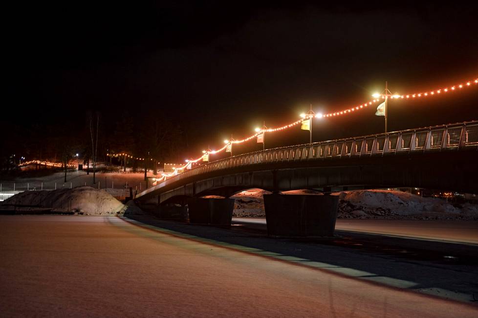 Korkeasaaren silta on valaistu punaisella valoketjulla. 