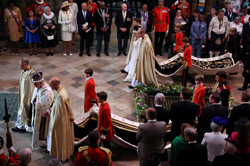 Kuningas Charles III ja kuningatar Camilla kävelevät ulos Westminster Abbeystä.