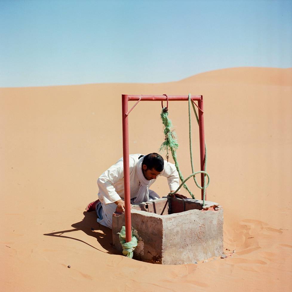 Mies tarkistaa kaivon vedenkorkeutta Marokon Merzougan keitaalla 8. lokakuuta 2022. M'hammed Kiliton kuva on Afrikan alueen voittaja pitkä valokuvausprojekti -sarjassa. Noin kaksi kolmasosaa Marokon keidasalueista on hävinnyt viime vuosisadalla jatkuvasti nousevien lämpötilojen, tulipalojen ja veden niukkuuden takia.