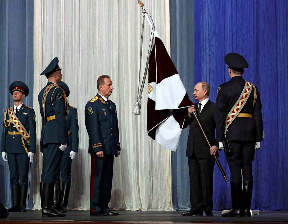 Presidentti Vladimir Putin piteli kansalliskaartin lippua Moskovan Kremlissä maaliskuussa 2017. Vieressä kansalliskaartin komentaja Viktor Zolotov.