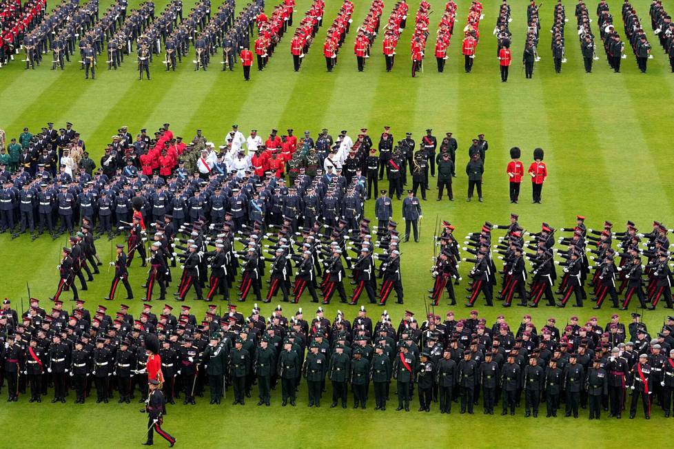 Asevoimien sotilaita marssimassa nurmikolla Buckinghamin palatsin edustalla.
