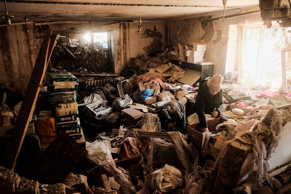 Pommitetun kerrostalon asukas etsi tavaroitaan sekasorron keskellä Kiovassa.