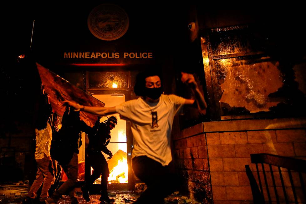 Mies pakeni sytytettyään poliisilaitoksen pääsisäänkäynnin tuleen yhdessä muiden mielenosoittajien kanssa George Floydin kuolemasta alkaneissa protesteissa Yhdysvalloissa. Kuva on otettu Minneapolisissa 28. toukokuuta.