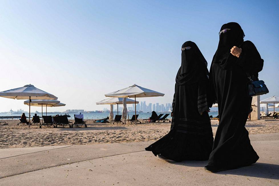 Naisten asema on Qatarissa hyvin heikko. Kuvassa kaksi niqab-huntua käyttävää naista kävelee rannalla Dohassa lähellä 974-stadionia.