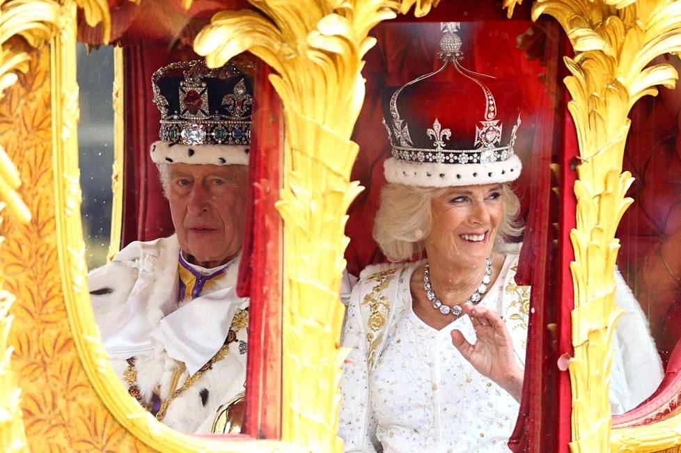 Kuningas Charles III ja kuningatar Camilla matkaavat Westminster Abbeyltä kullatuissa vaunuissa kruunajaisseremonian jälkeen.