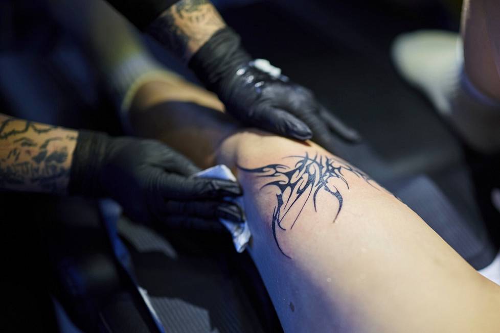 When the tattoo is finished, Elisa Kiljunen removes the excess ink from the skin.  In Iida Rantanen's opinion, the picture turned out to be rockier than he thought.