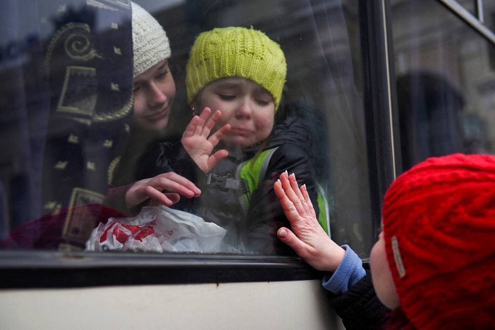 12-vuotias Aleksandra ja kuusivuotias Esya vilkuttavat bussista äidilleen. Odessan juutalaisen yhteisön jäseniä pakeni Ukrainasta maanantaina.
