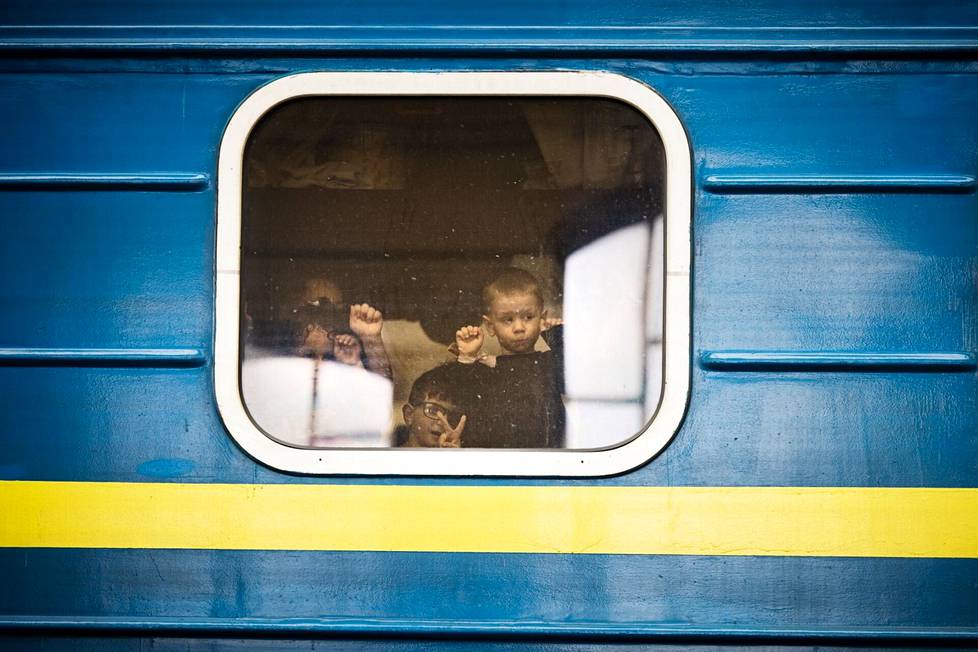 Lapsia junan kyydissä Lvivin asemalla lähdössä Puolaan.