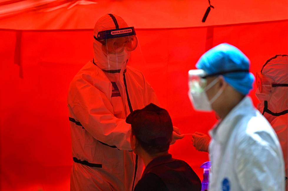 A medical worker prepares to take a swab sample from a man to be tested for the COVID-19 coronavirus in Wuhan, Chinas central Hubei province on May 19, 2020.
