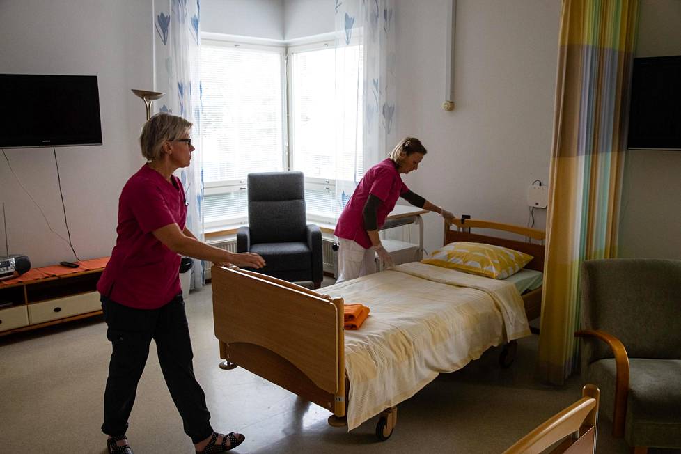 Sairaala-apulaisten tiiminvetäjä Tarja Enqvist ja vapaaehtoistoiminnan ohjaaja Nina Vuojela valmistelevat huonetta uutta potilasta varten.