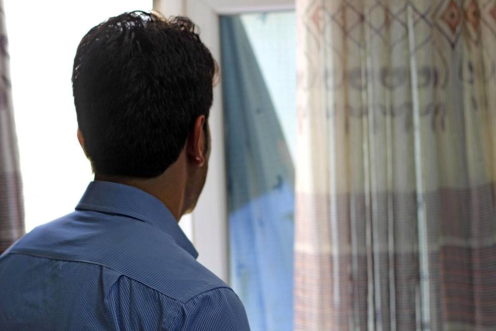 Mohammad Tamim, 27, katsoo ulos ikkunasta Kabulin asunnossaan. Hän ei halunnut kasvojaan julkisuuteen.