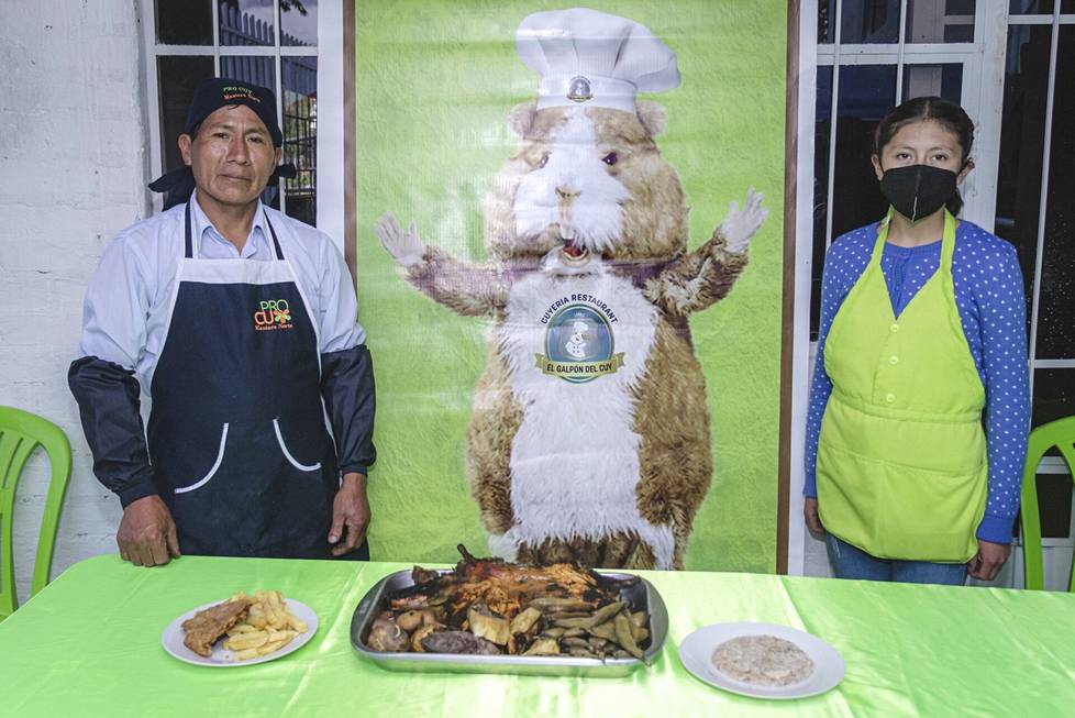 Eloy Tomialán, executive director of the breeders' organization, and daughter Laura Quispe present their restaurant's guinea pig meals.