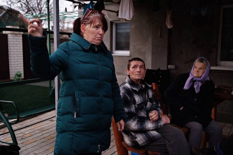 Tetjana ja Volodja Pejek sekä isoäiti Jelena Nastasijenko perheen pihalla Antonivkassa, muutaman sadan metrin päässä Antonivkan sillasta. 