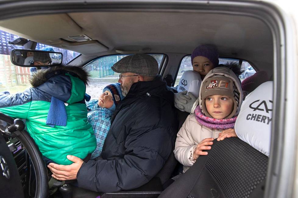 Семья Юлии Чалой влезает в машину брата, чтобы отвезти домой продукты и вещи, полученные в Бородянской школе. ФОТО: КАЛЛЕ КОПОНЕН / HS
