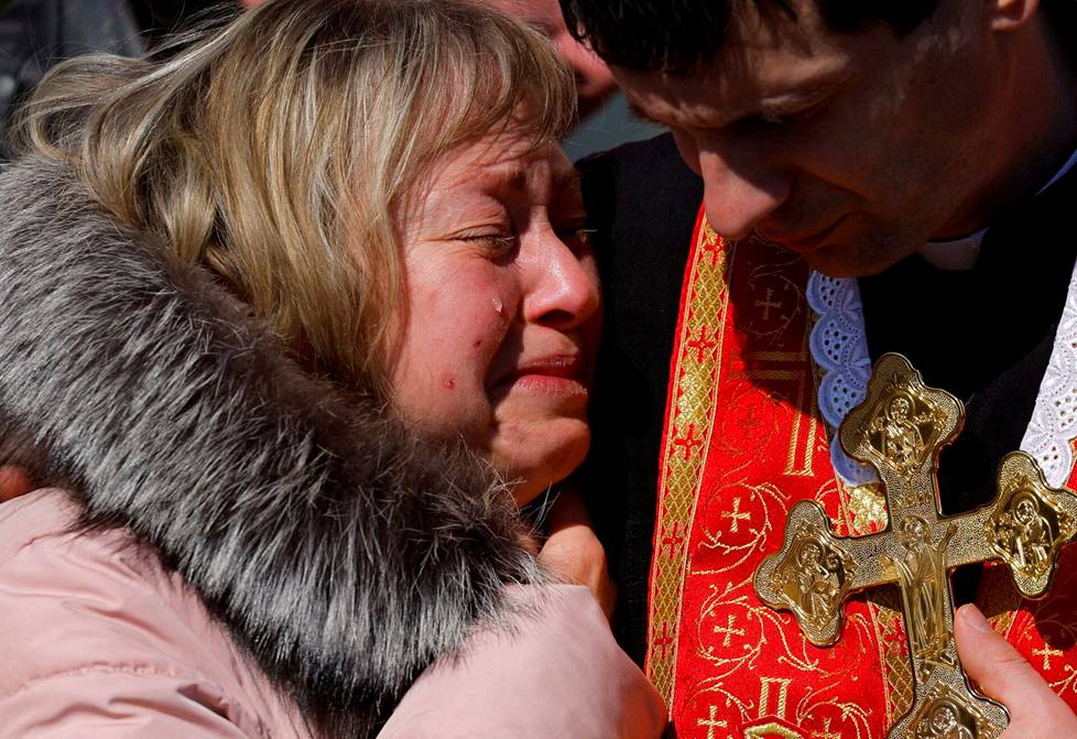 Olena koetti pidätellä kyyneliä 25-vuotiaan poikansa hautajaisissa Lvivissä maanantaina.