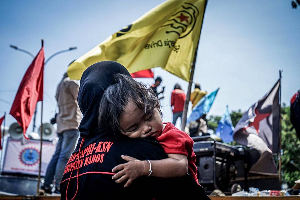 Indonesialaisnainen osallistui protestiin syliin nukahtaneen lapsensa kanssa Etelä-Sulawesin Makassarissa.