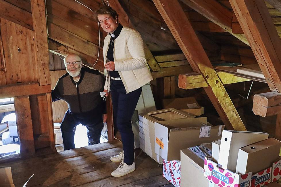 Retired Pastor Erkki Jaskari and current Pastor Satu Ruhanen in the attic of the Polvijärvi rectory, where the old altarpiece had once been moved from the belfry.  Jaskari picked up a painting roller under the roof of the lapland roughly from behind Ruhanen.