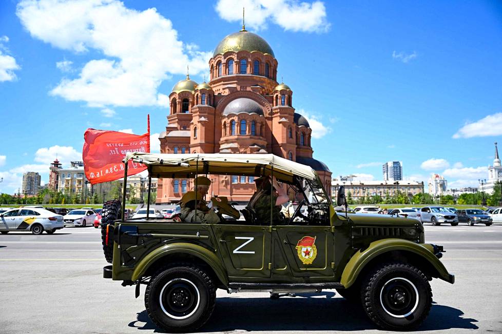 Turisteja Volgogradissa kaupunkikierroksella 6. kesäkuuta pukeutuneina toisen maailmansodan univormuja jäljitteleviin vaatteisiin. Auton kyljessä on Z-kirjain, josta on tullut Venäjän hyökkäystä tukevien symboli.