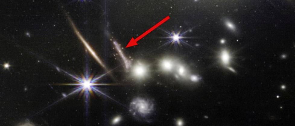 Suurennos avaruusteleskooppi James Webbin isosta syvän avaruuden kuvasta heinäkuulta. Nuolella merkitystä kaaresta löytyi kiinnostavia ikivanhoja tähtijoukkoja. 
