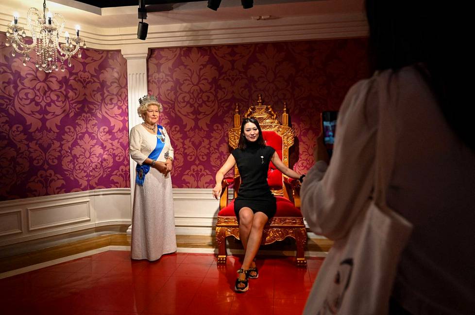 Nainen poseerasi kuningatar Elisabetia esittävän vahanuken kanssa Madame Tussaudsin vahamuseossa Pekingissä.