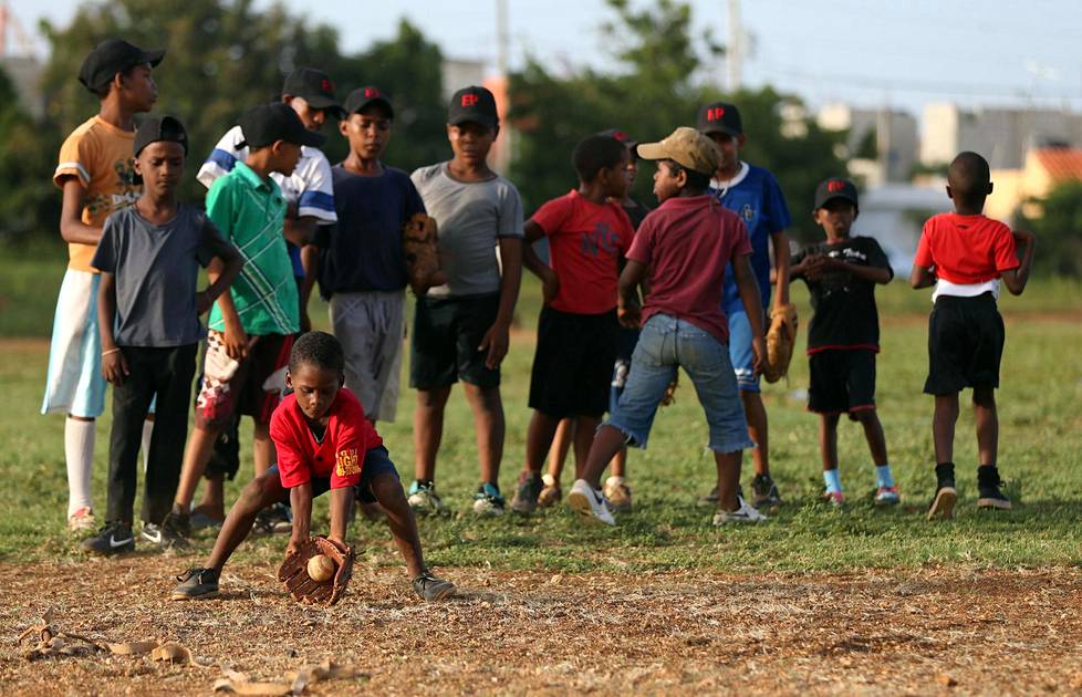 Joukko lapsia harjoitteli maahan osuvien baseball-lyöntien kiinniottamista San Pedro de Macorísin kaupungissa Dominikaanisessa tasavallassa lokakuussa 2014.