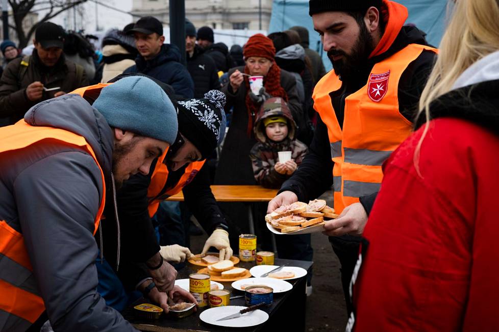 Vapaaehtoiset tarjoavat lähtijöille syötävää.
