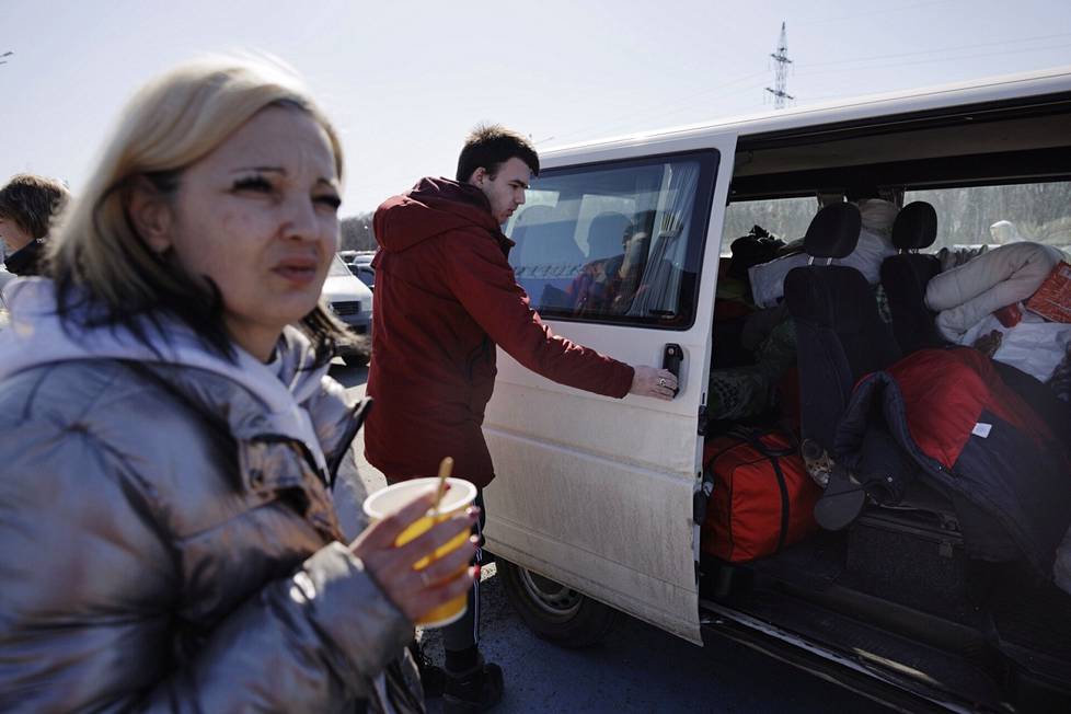 Кирилл Бойко открывает дверь микроавтобуса, который привез семью из Мариуполя в Запорожье. На переднем плане - мать Наталья Бойко. 