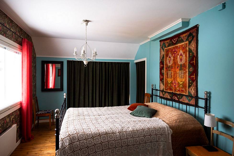 Sinisen sävyt koetaan yleisesti rauhoittaviksi, ja makuuhuoneen seinälle Isosomppi onkin valinnut turkoosin maalin. Ryijy on Isosompin mummon tekemä.